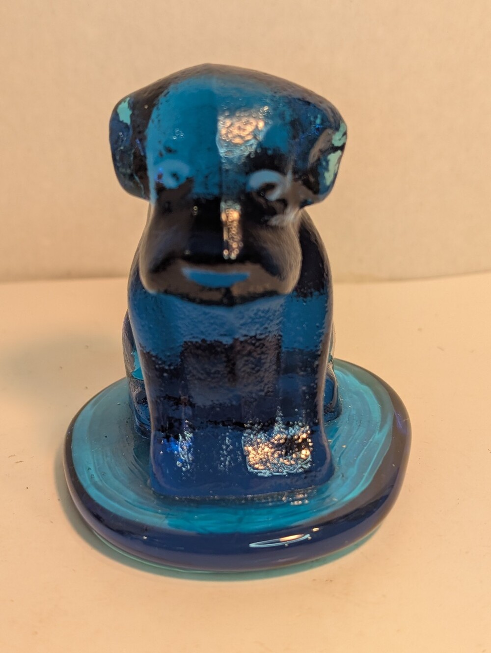 This item is a vintage "Pooch" dog figurine made of blue art glass.
